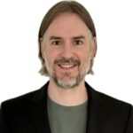 mauro rossi headshot black jacket over green sweater